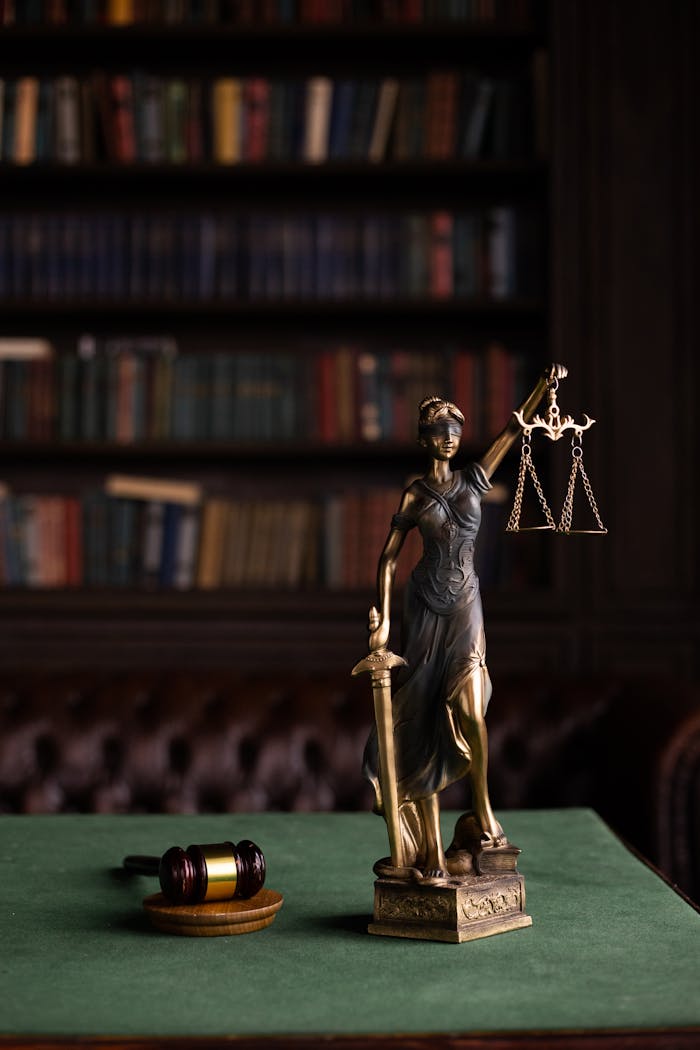 hero-img-02 Lady Justice and gavel on a table in a classic law library setting.